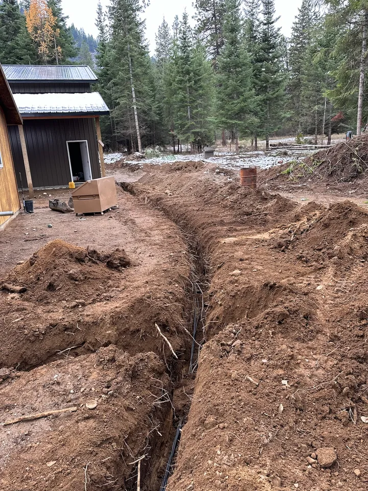 French drain trench with fabric and drain rock running along a house foundation
